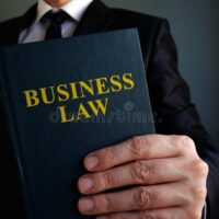 businessman-holding-business-law-book-172063569
